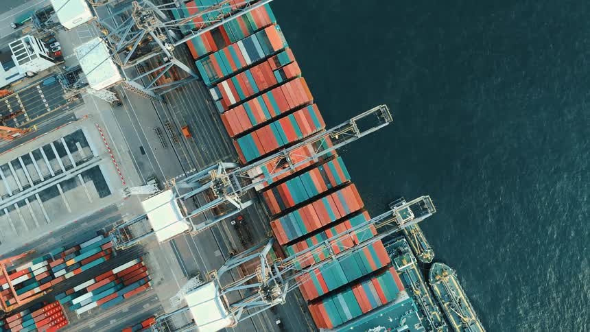 Aerial of a loaded cargo ship on water body at a shipping dock during daytime