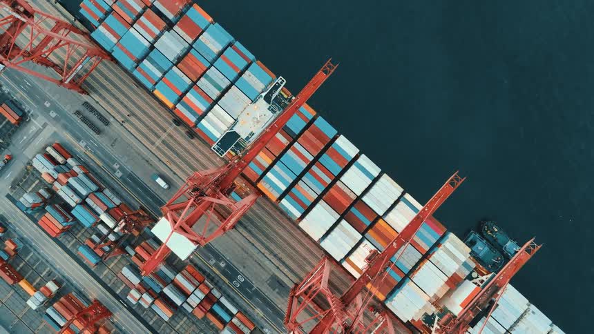 Aerial view of cranes moving colorful containers at a seaport