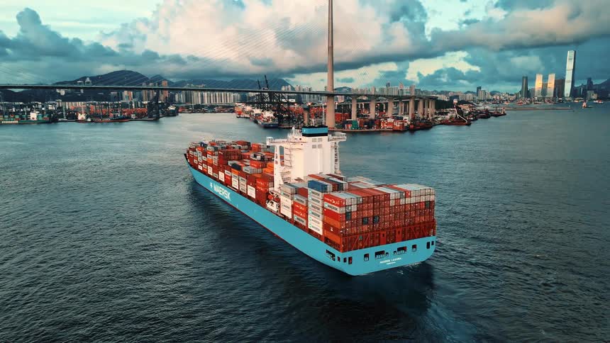 A wideangle view of a vibrant container yard shows cranes and trucks actively loading and unloading freight