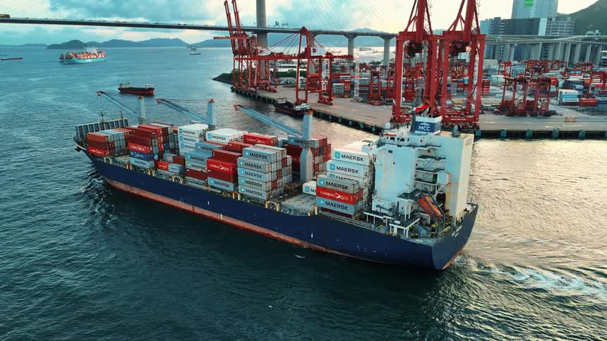 Barges carrying containers in the ocean immediately offshore