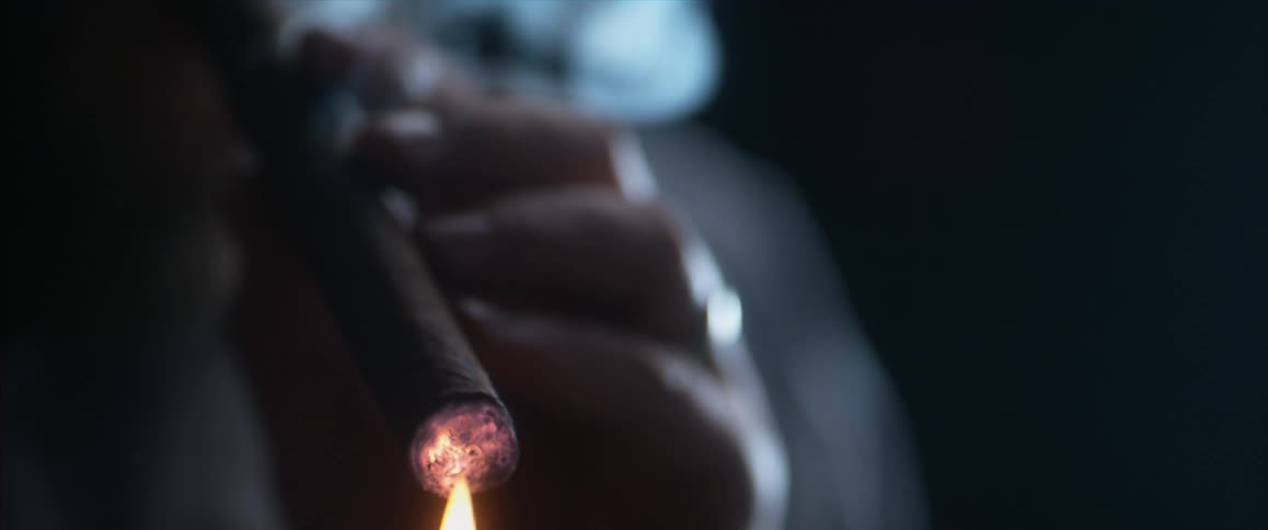 Man using a match to light a cigar