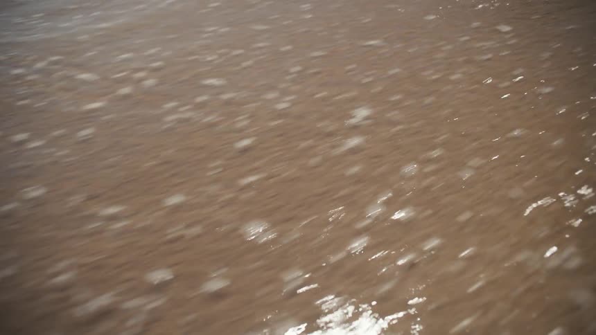 The tide flows over the sand