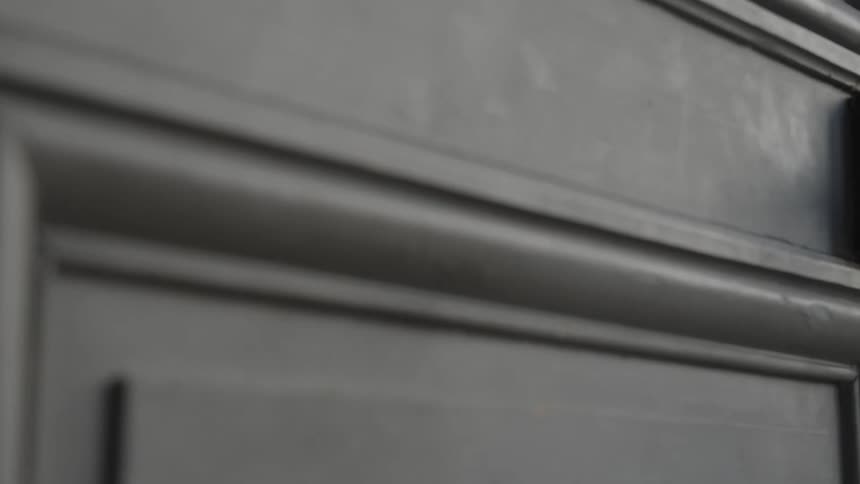 A black door close up is swinging open and shut