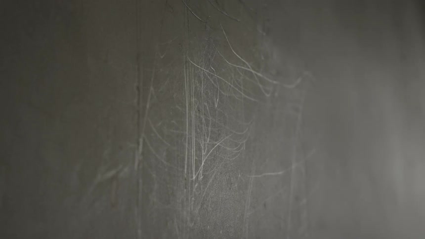 Closeup of a scratched textured wall surface with neutral lighting