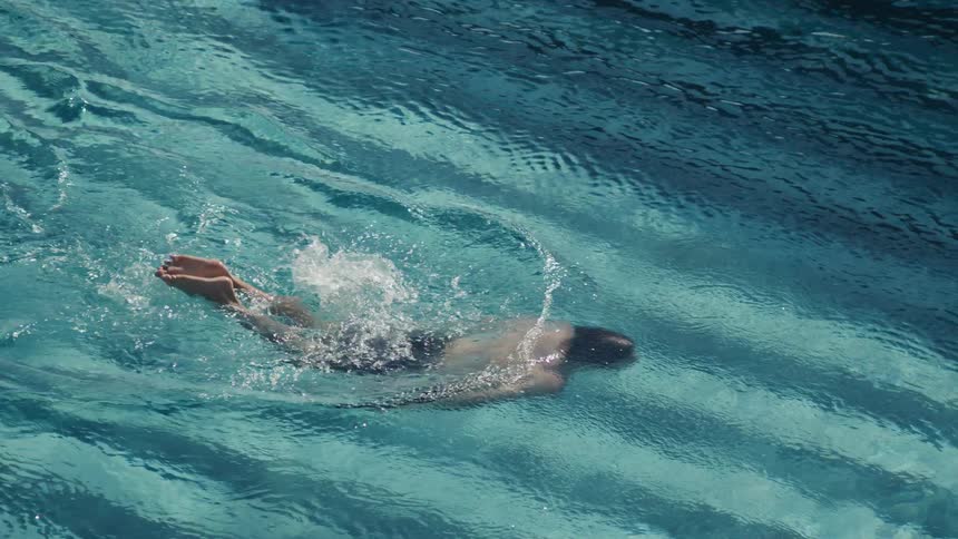 A man swims across the pool