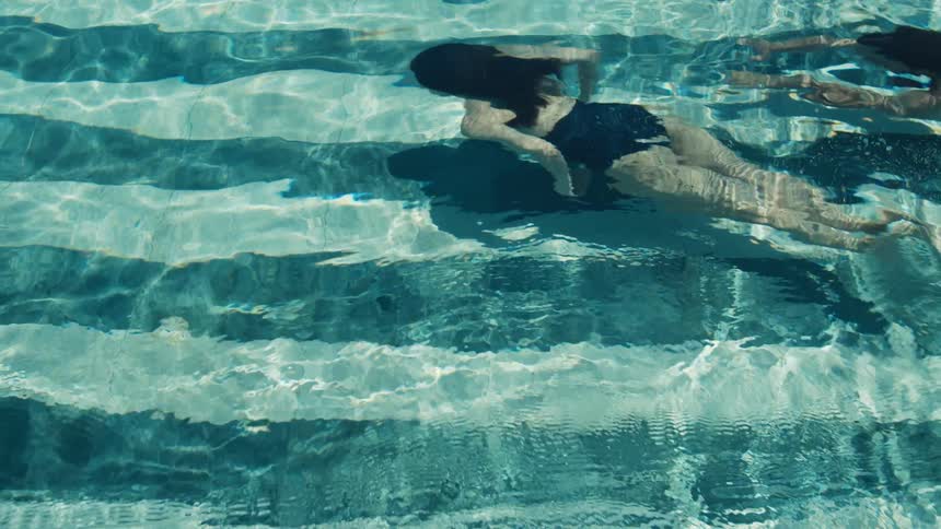 Couple swimming underwater in a swimming pool