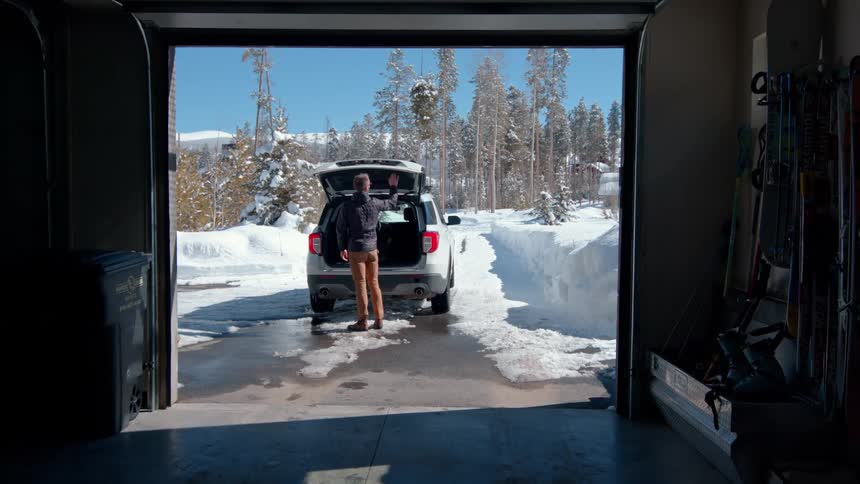 Man storing a suitcase inside a car