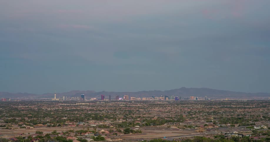 A wide aerial view of a city with a distant mountain skyline