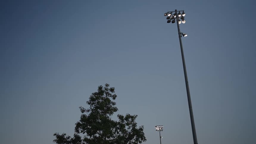 Park lights turn on at dusk