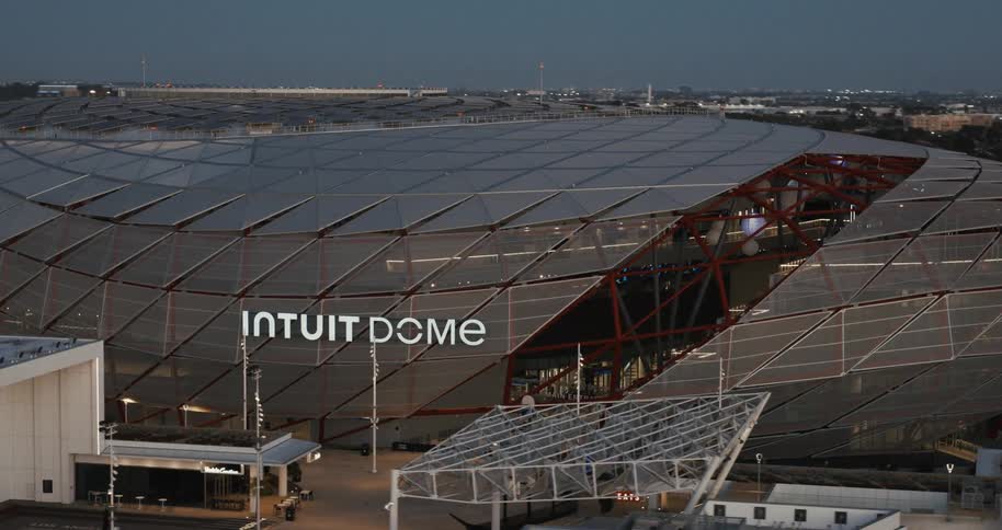 A stadium view at sundown with parts of the roofing missing