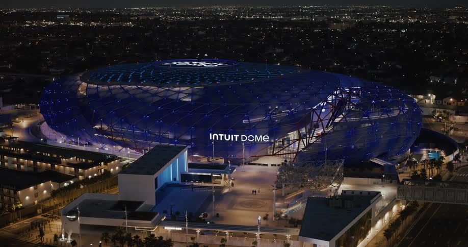 Aerial panorama of a stadium with blue lights and illuminated at night