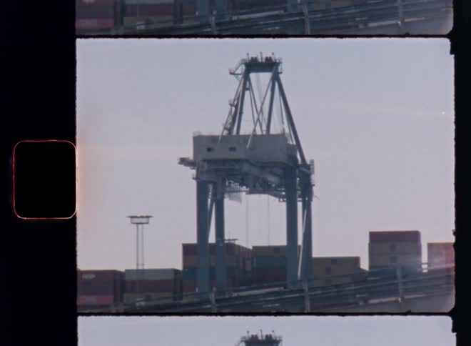 Industrial crane stands tall at busy port with containers
