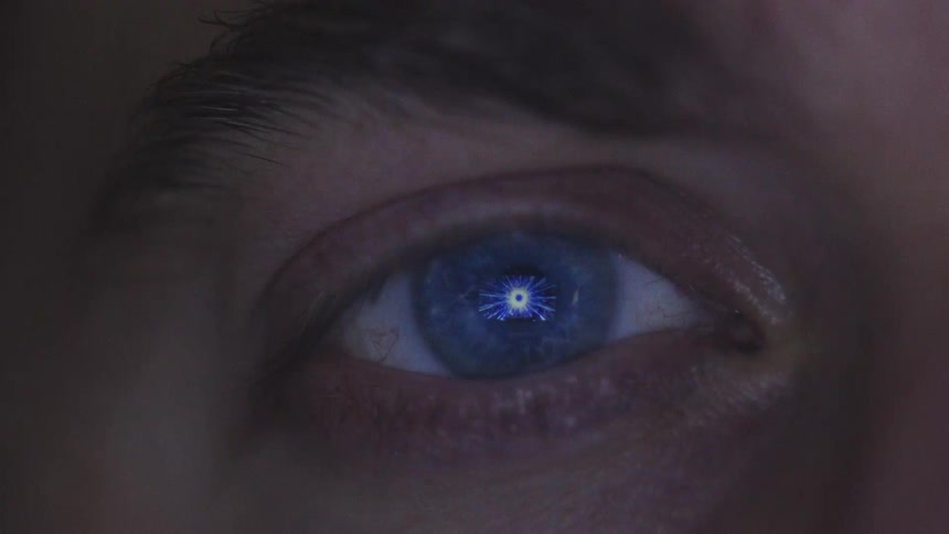 Blue eye of a person with a light reflecting