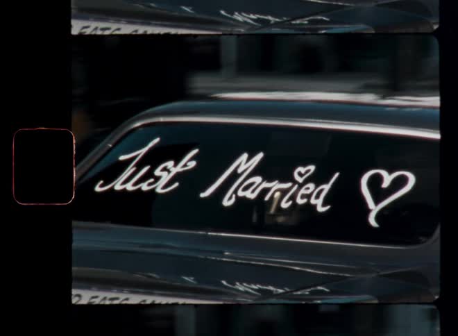 A car driving away with just married written on the back windshield