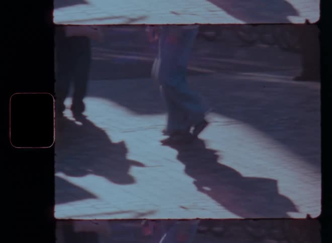 Shadows of people cast on the ground in a sunny outdoor setting