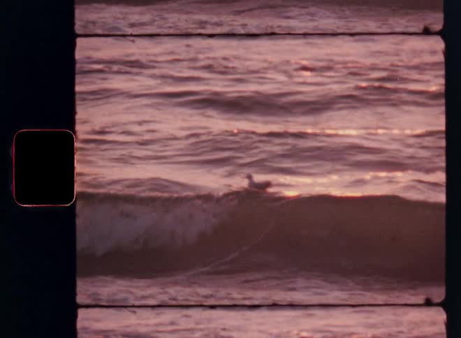 Ocean waves reflect pinkish hues during sunset
