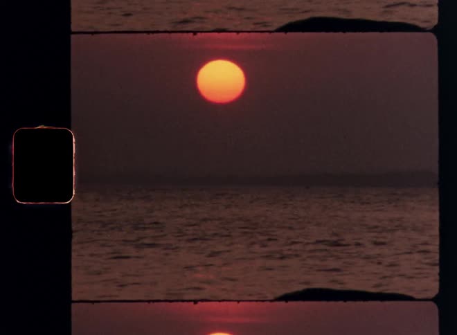 Landscape of a calm sea with the reddish sun on the horizon