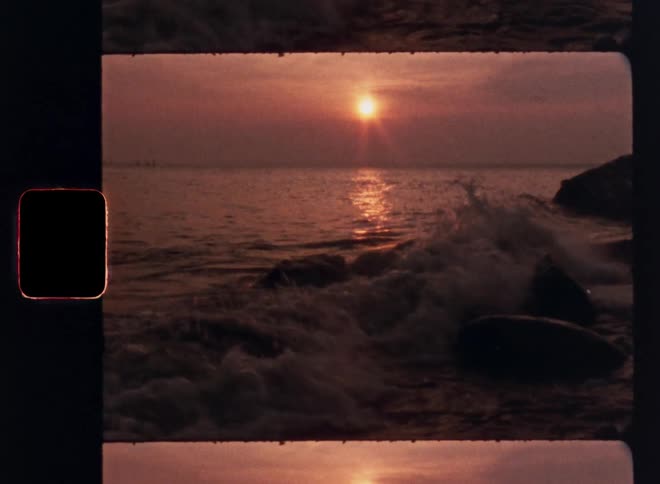Small wave on a beach with the sun on the horizon
