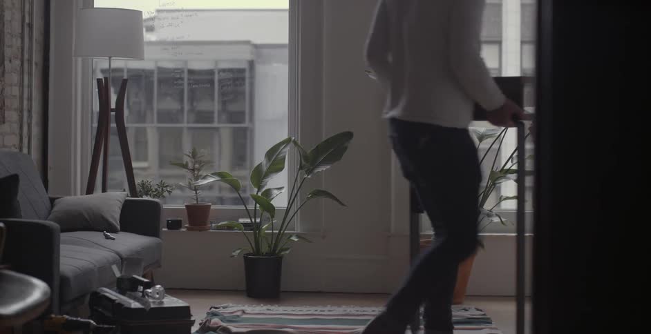 Two men move a piece of furniture in an apartment