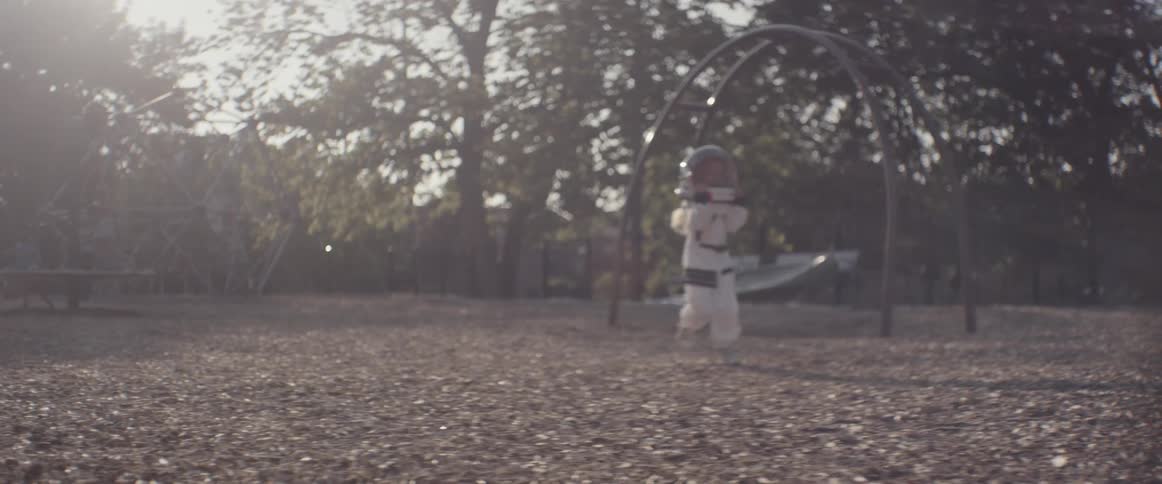 A child runs around in a space suit