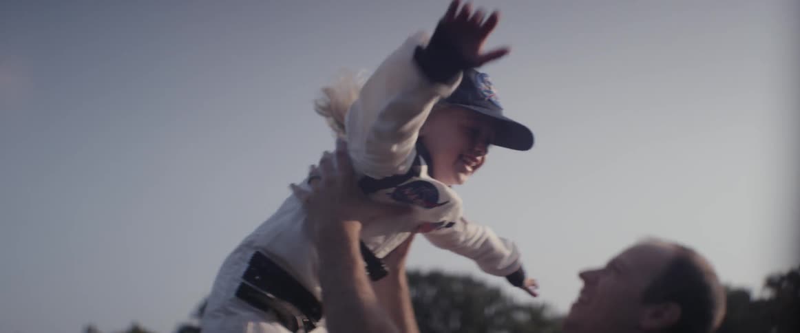 A man throws a young girl into the air and catches her