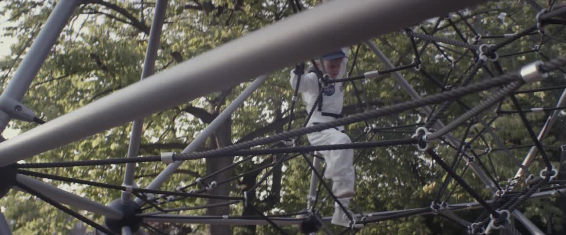 A girl climbs in a jungle gym