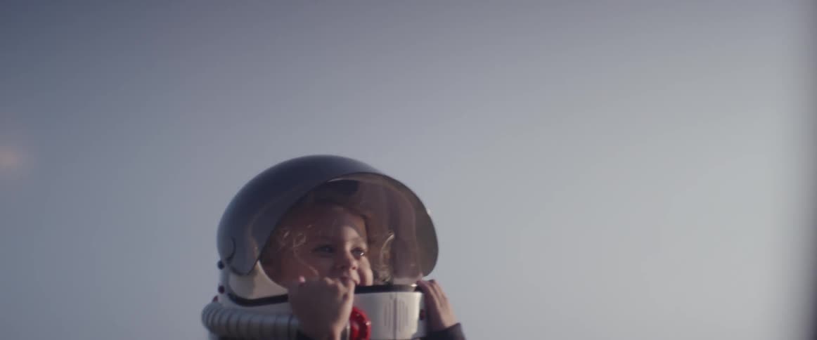 A child is thrown in the air wearing a space costume