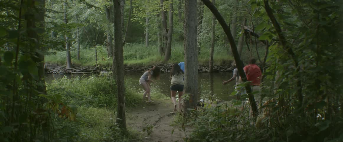 People run towards the water in the forest