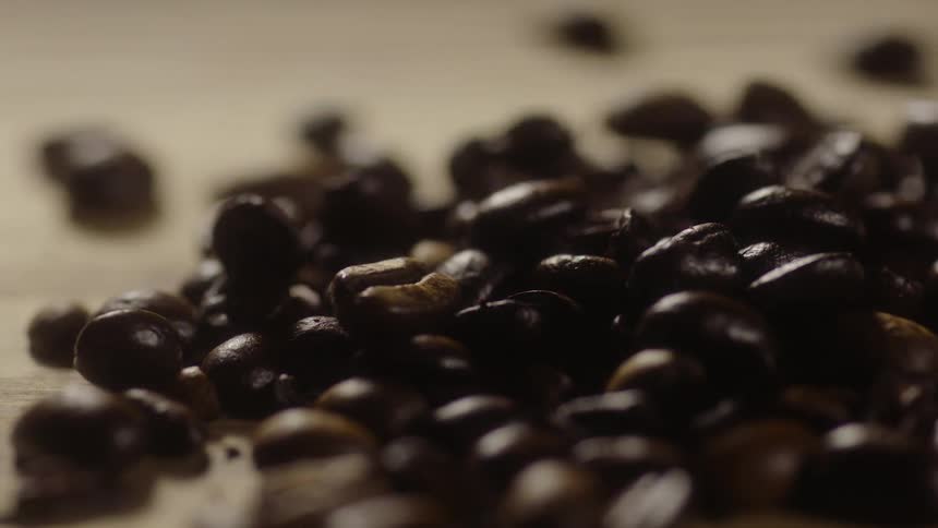 Coffee beans falling onto a pile of coffee beans