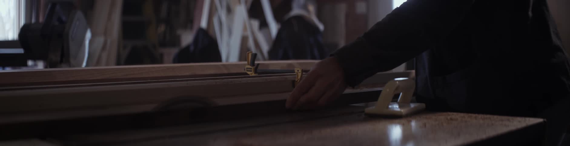 A board is pushed through a saw