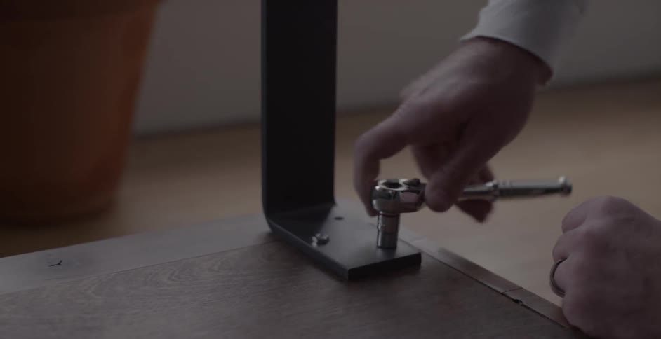 A man attaches a table leg to a table