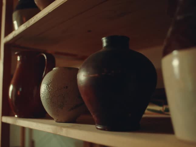 Vases and pots line the shelves of a shelving unit
