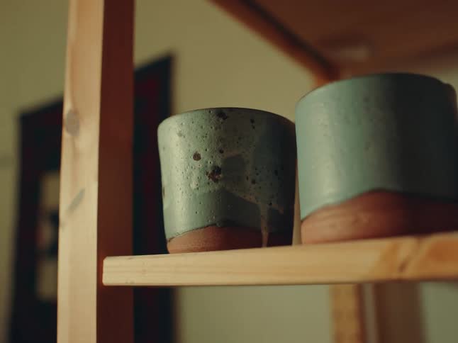 Two deep blue bowls on a wooden shelf inside the kitchen