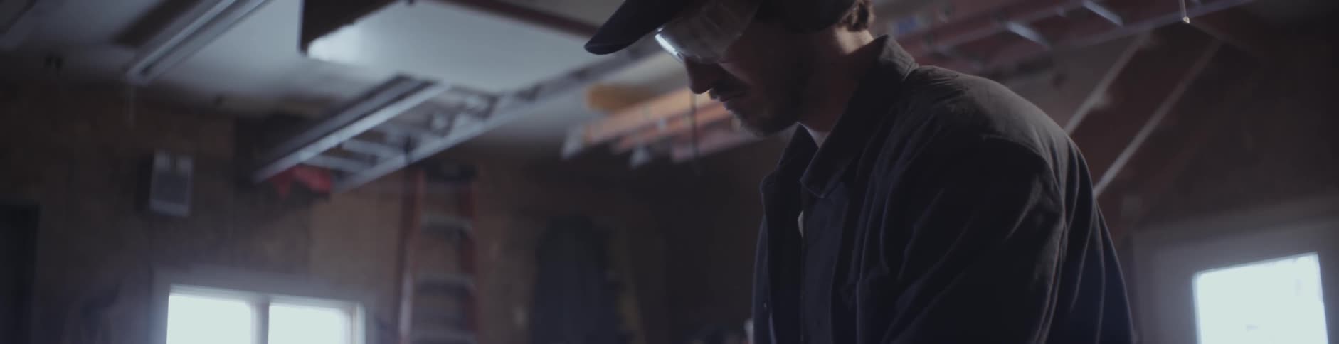 A man is working in a warehouse wearing goggles