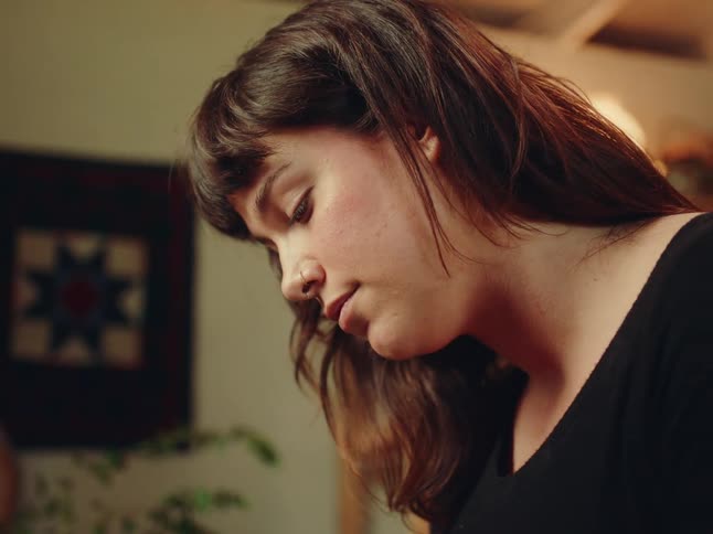 A woman is looking down in her home