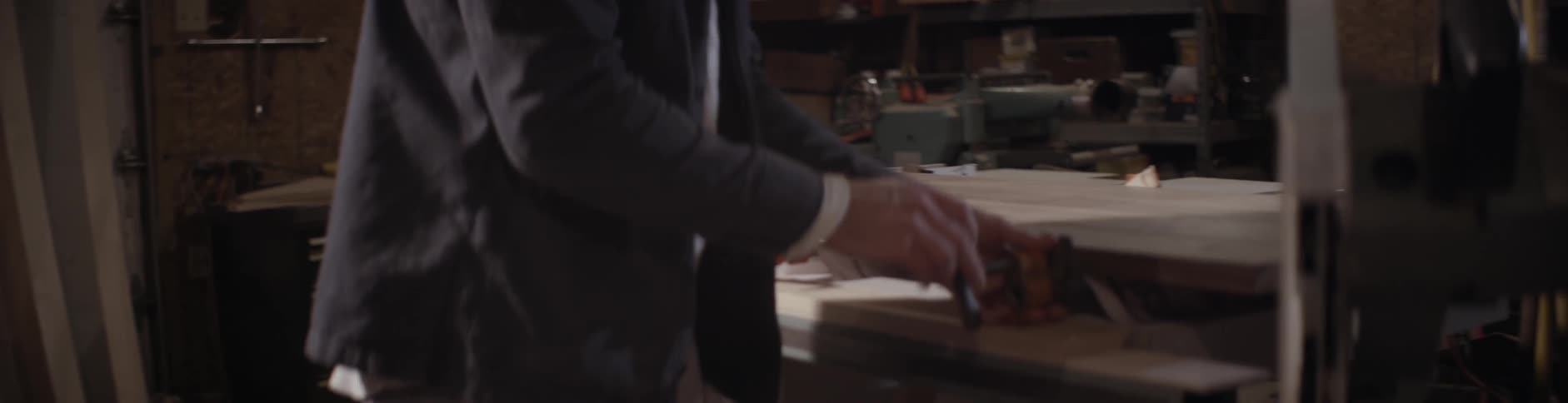 A man adjusts a piece of wood in a vise grip