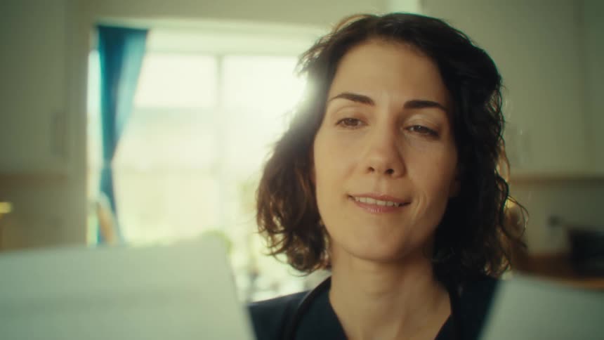 Woman carefully looks at sheets of paper spread in her hands