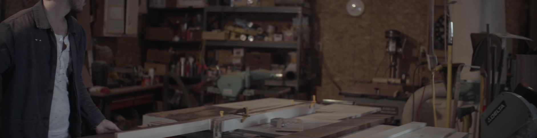 A man lifts up a board and places it on a table