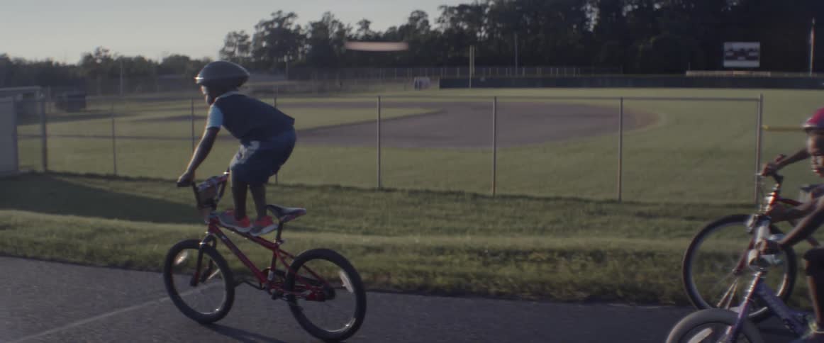 Children riding bikes near a track