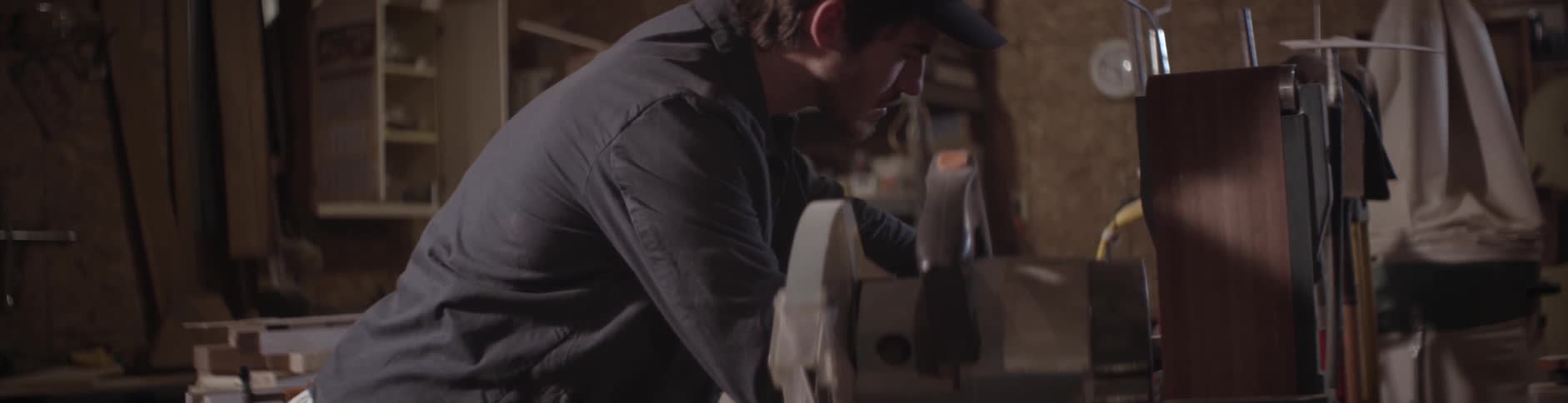 A man uses a mallet on a piece of lumber