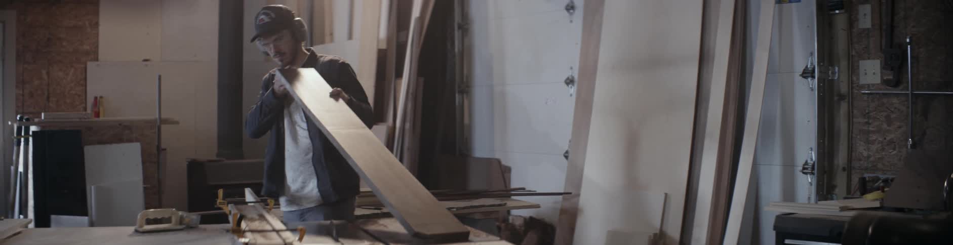 A man examines a long wooden board