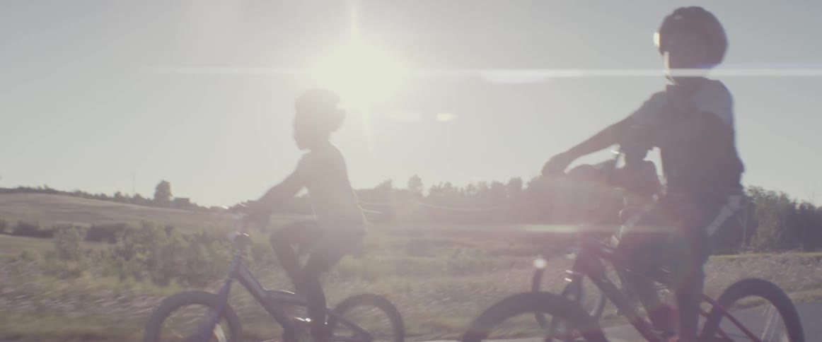 Young children ride bicycles on a sunny day