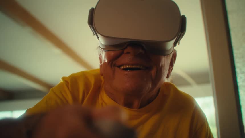 Elderly man smiling while playing a vr game