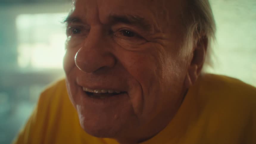 Elderly man sitting in a room with a happy expression