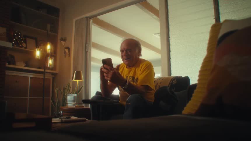 Elderly man smiles while having a video call at home