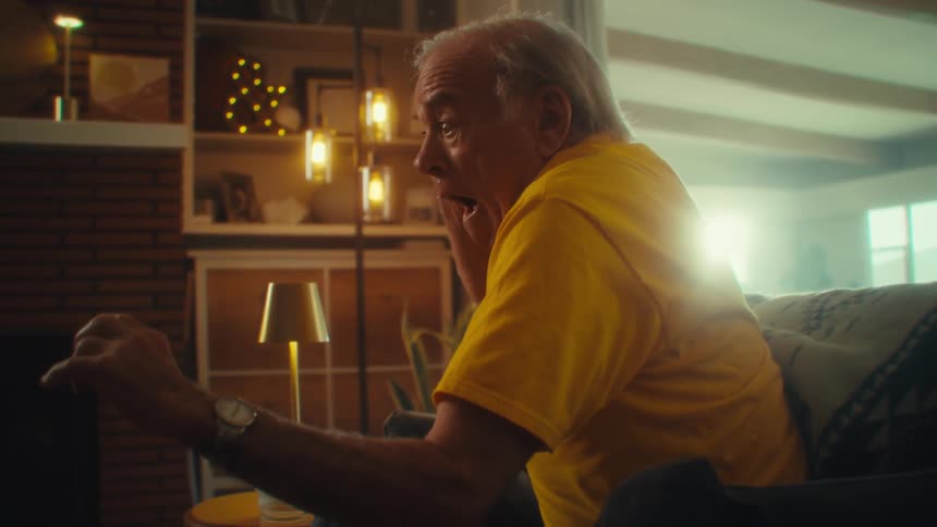 Elderly man smiles excitedly while extending his arms forward