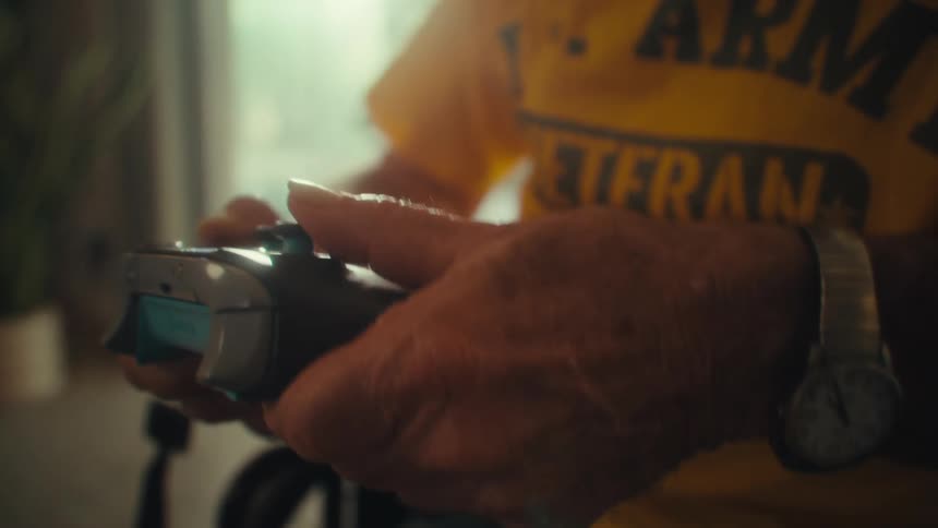 Elderly hands firmly hold a video game controller
