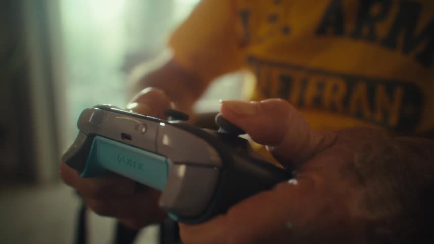 An elderly man holding a gaming controller enjoying himself in the living room