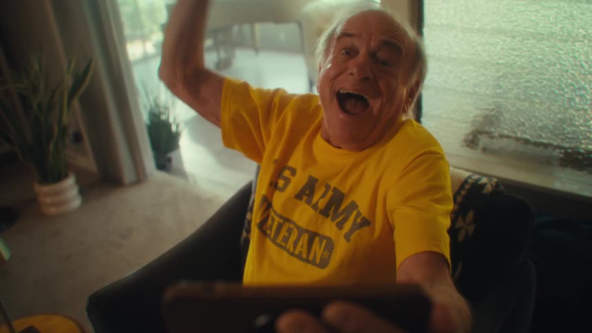 Elderly man celebrates excitedly raising his arm