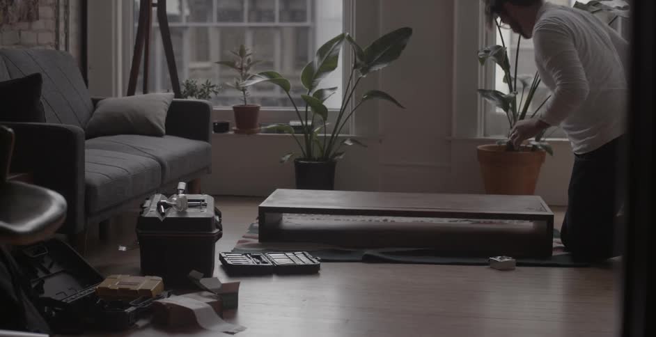 Men assemble a piece of furniture on a living room floor